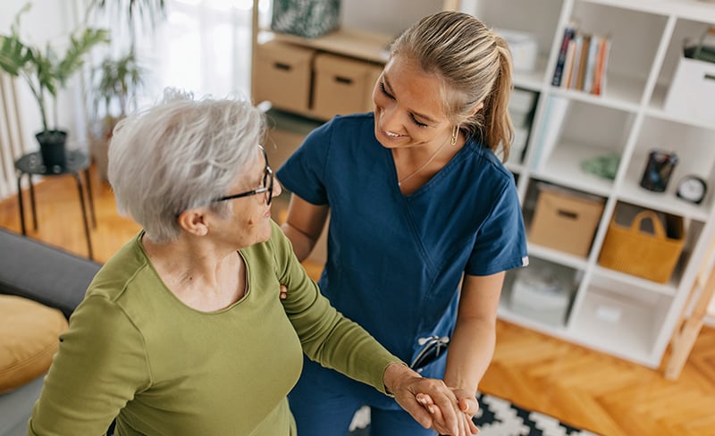 Nurse supporting an elderly woman